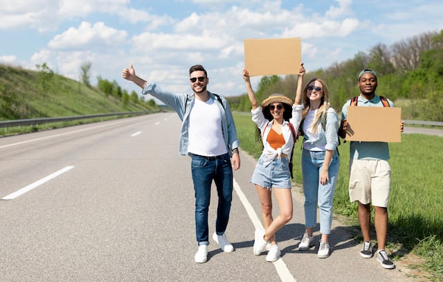 Groupe d'amis en train de faire du stop sur le bord de la route