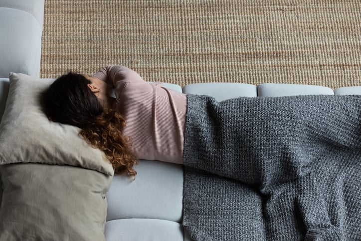 Une femme dort sur un canapé 