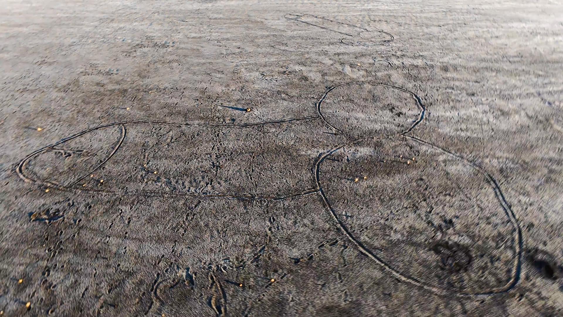 Un dessin obscène sur la plage