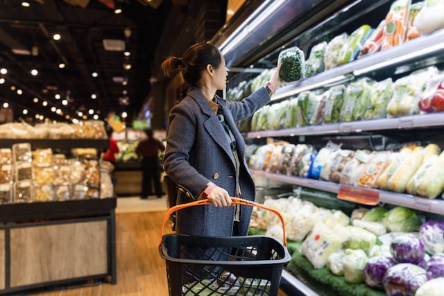 Une femme en train de faire des courses dans les rayons d'un supermarché