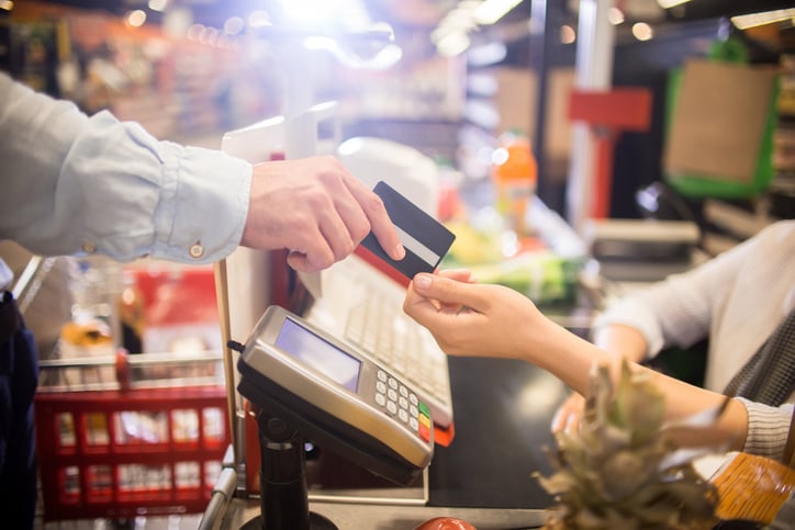 Une personne paie par carte dans un supermarché