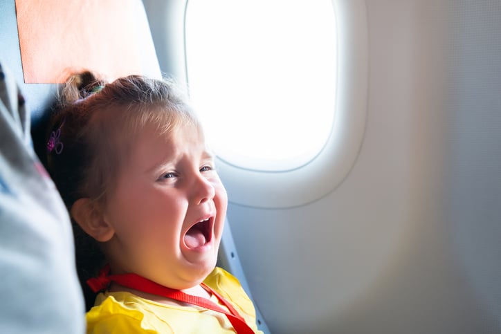 Une fillette pleure dans un avion