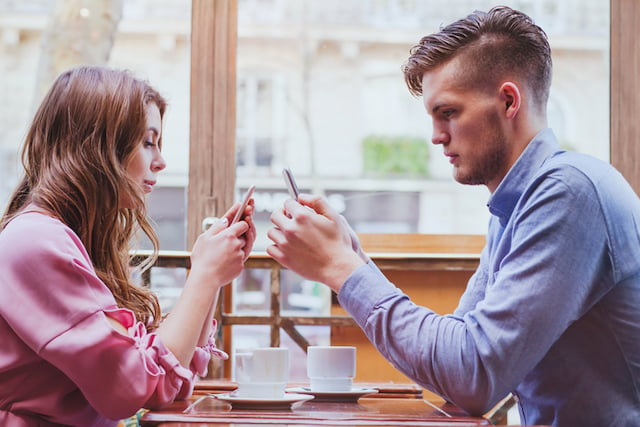 Un couple utilisant son smartphone au restaurant 