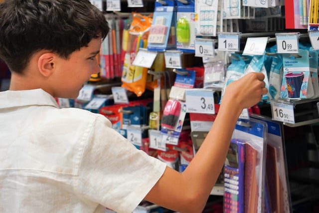  Un enfant choisissant des fournitures scolaires pour la rentrée scolaire dans un grand magasin