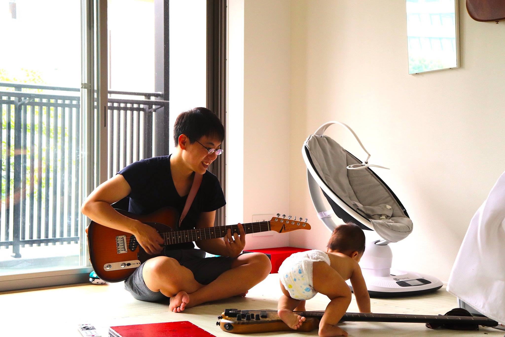 Daisuke Hori joue de la guitare près d'un bébé