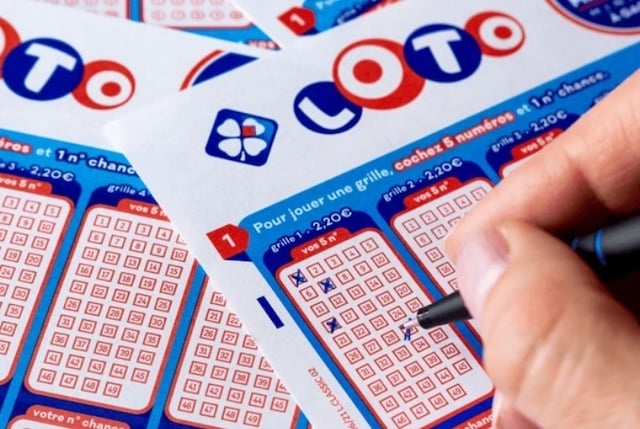 Un homme en train de remplir une grille de Loto