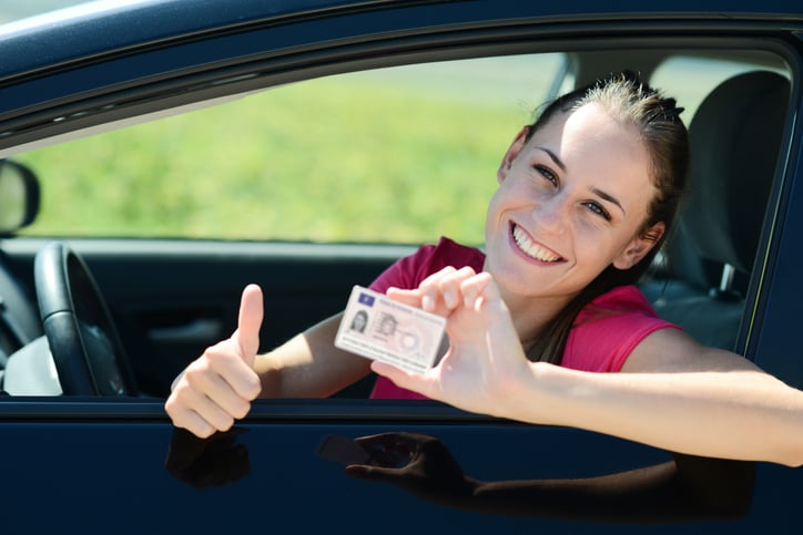 Jeune femme affiche avec fierté son nouveau permis de conduire