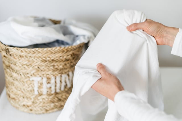 Une personne âgée qui tient un drap blanc propre entre ses mains