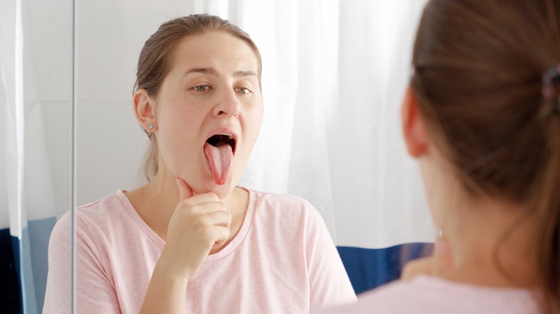 Une femme tire la langue dans le miroir