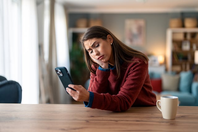 Une femme en train de lire un message sur son téléphone