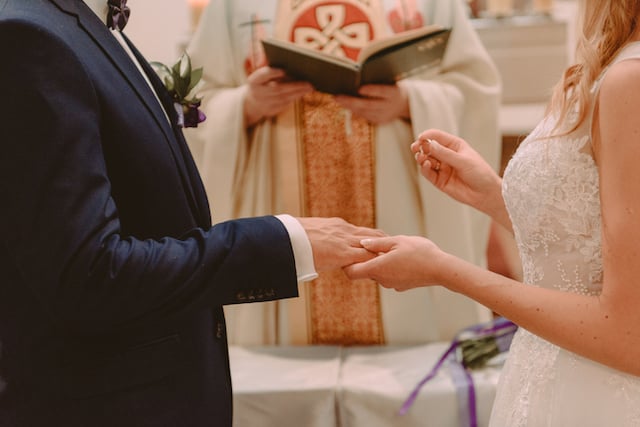 Un couple de mariés pendant l'échange des alliances 