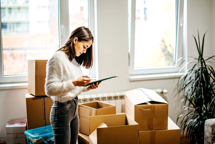 Une femme au milieu de cartons de déménagement