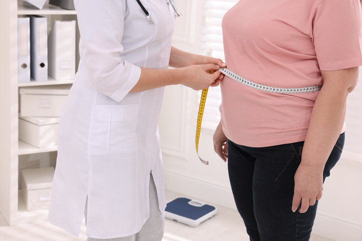 Un médecin mesure le tour de taille d'un patient