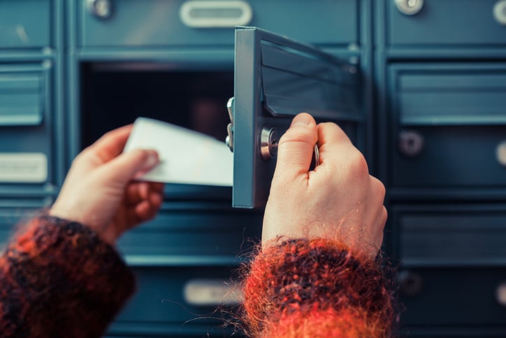 Une personne ouvre sa boîte aux lettres