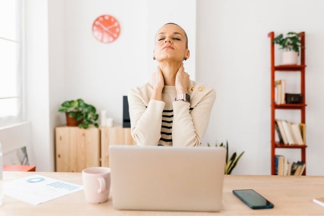 Une femme au travail qui semble anxieuse et fatiguée