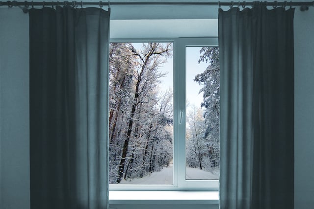 Fenêtre dans une pièce donnant sur un paysage hivernal