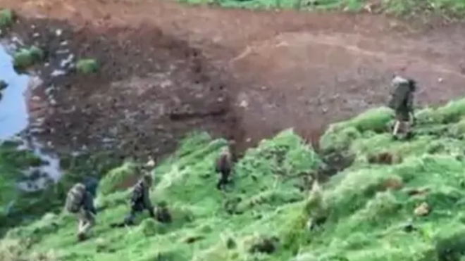 Photo de 4 personnes, en tenues de camouflage, que l'on suppose être Tom Philipps et ses enfants, disparus depuis 3 ans