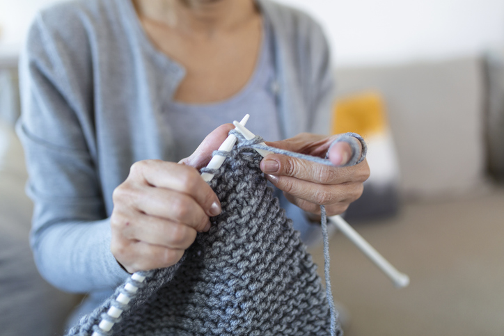 Une femme tricote un pull