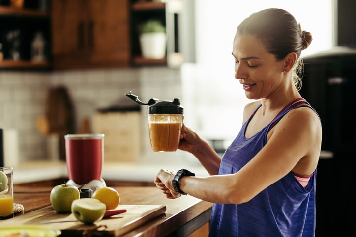 Une femme regarde sa montre au moment de manger