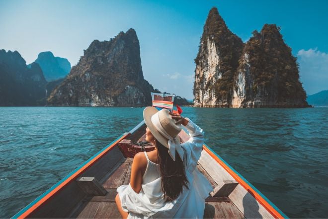 Une femme de dos sur un bateau en Thaïlande