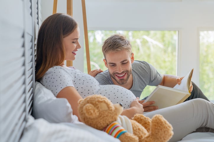 Un homme et une femme enceinte lisent un livre