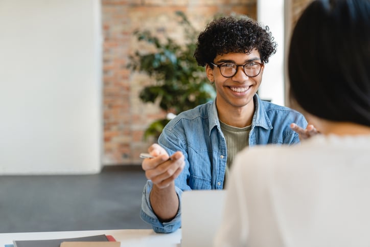 Un jeune homme souriant lors d'un entretien d'embauche