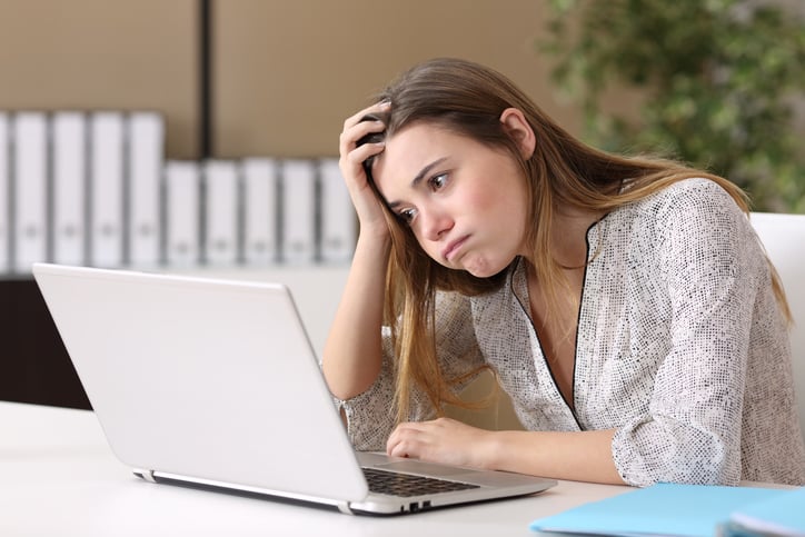 Une jeune femme souffle devant son ordinateur