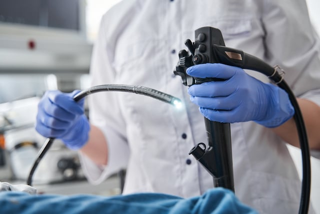 Une médecin tenant l’endoscope pendant une endoscopie 