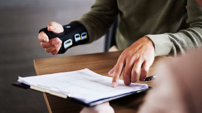 Un homme au bureau avec une attelle au poignet