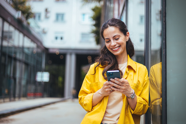 Une femme heureuse en train d'envoyer un sms