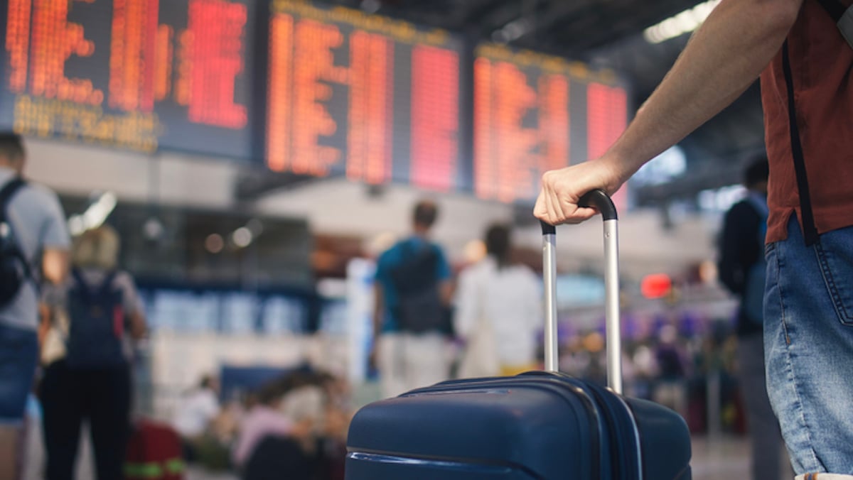 Un voyageur avec son bagage à l'aéroport