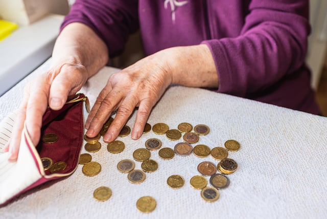 Une personne à la retraite qui compte ses pièces