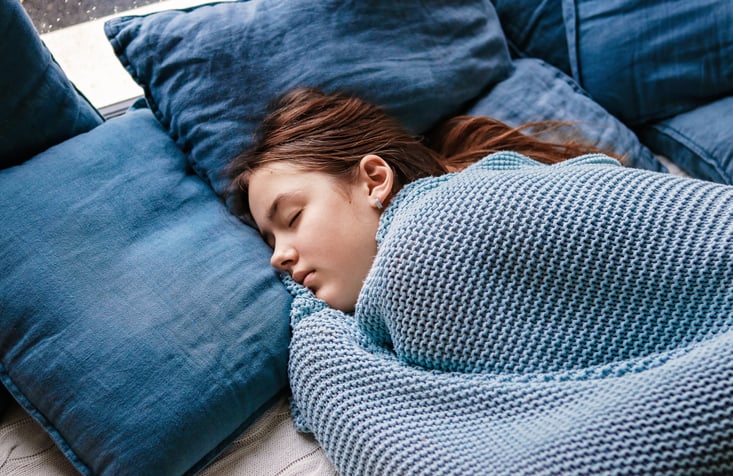 Une femme dort sous une couverture