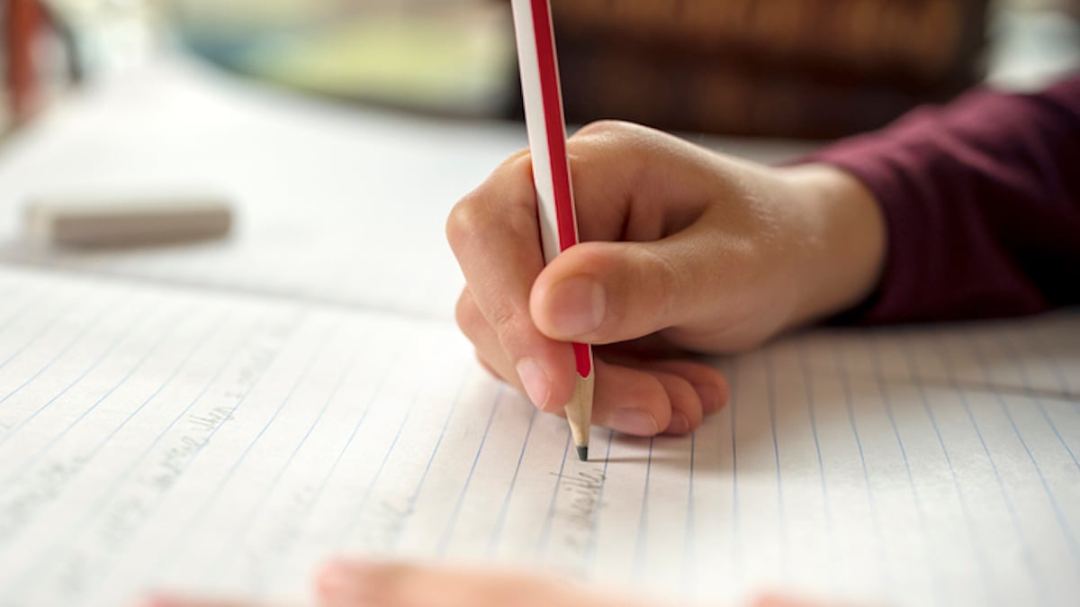 Un élève écrit sur son cahier