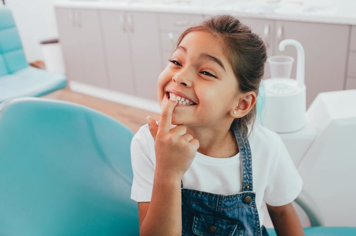 Une petite fille montre ses dents