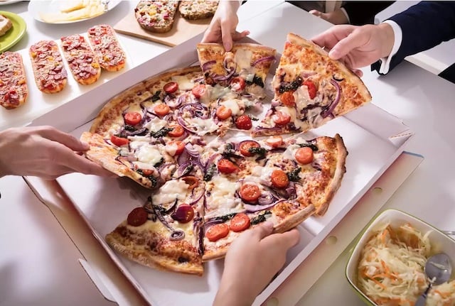 Des invités en train de manger une pizza