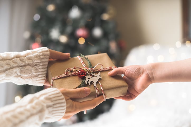 Une personne offre un cadeau de Noël