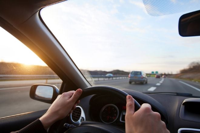 Homme au volant de sa voiture sur autoroute