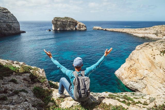 Un jeune voyageur en train d'admirer le paysage à Malte