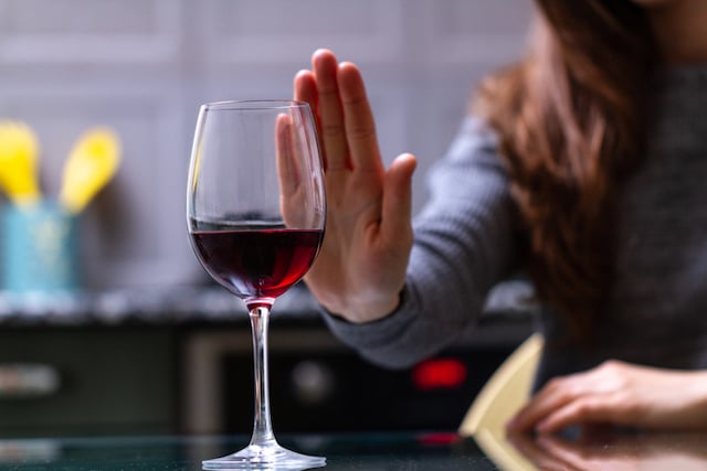 Une femme qui refuse un verre de vin