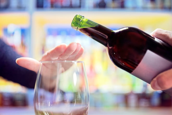 Un homme refusant de boire un verre de vin