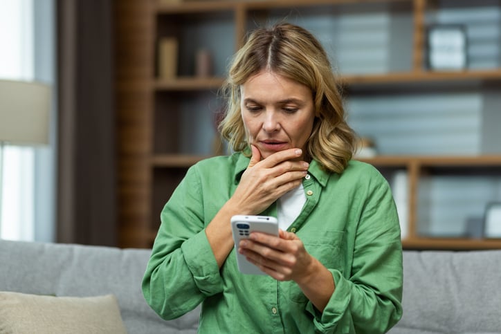 Une femme inquiète regarde son téléphone