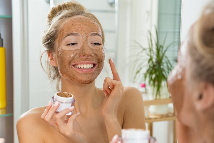 Une femme s'applique un masque sur le visage