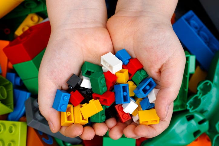 Un enfant tient des Lego dans ses mains