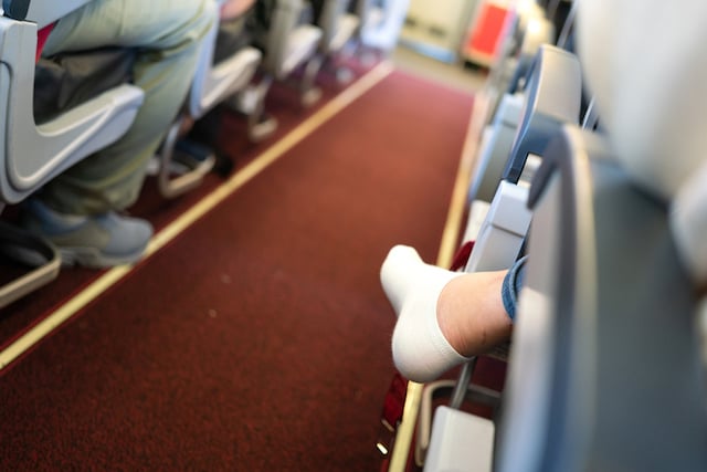 Une passagère en chaussettes dans un avion