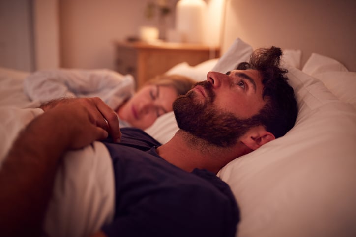 Un homme dans son lit ne dort pas