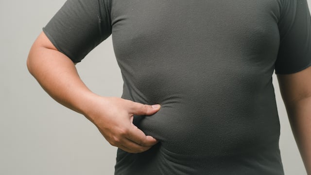 Un homme qui attrape sa graisse abdominale 