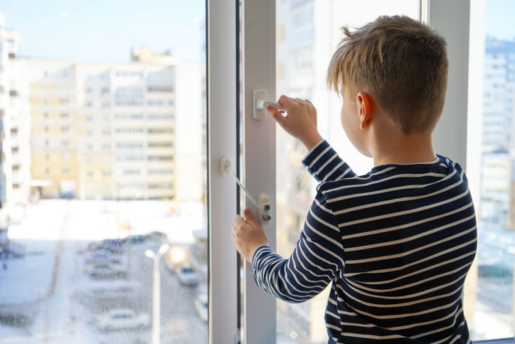 Un enfant ouvre la fenêtre d'un appartement