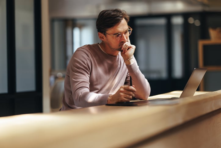 Un homme réfléchit devant son ordinateur