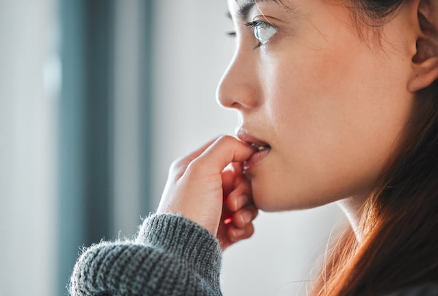 Une femme qui se ronge les ongles